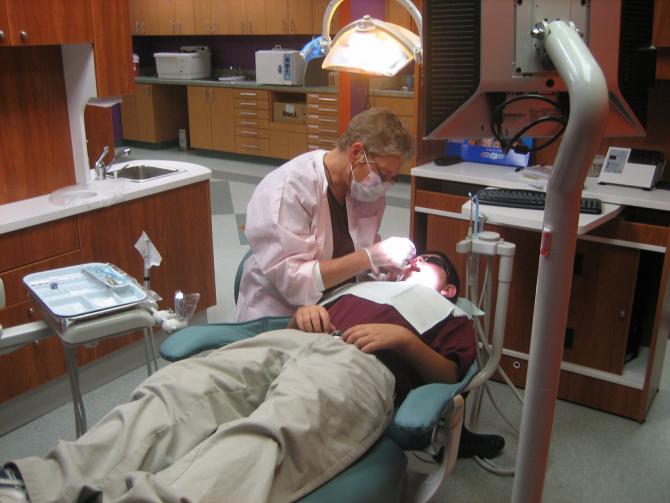 Kim Anderson performs a dental exam